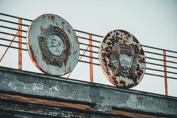 Propaganda Case - two soviet-era round signs on a building marquee. Lenin appears one of them